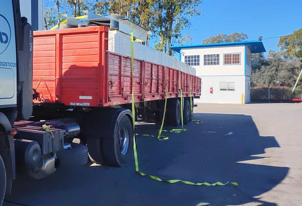 Carga de materiales amarrada con eslingas sobre semirremolque baranda volcable